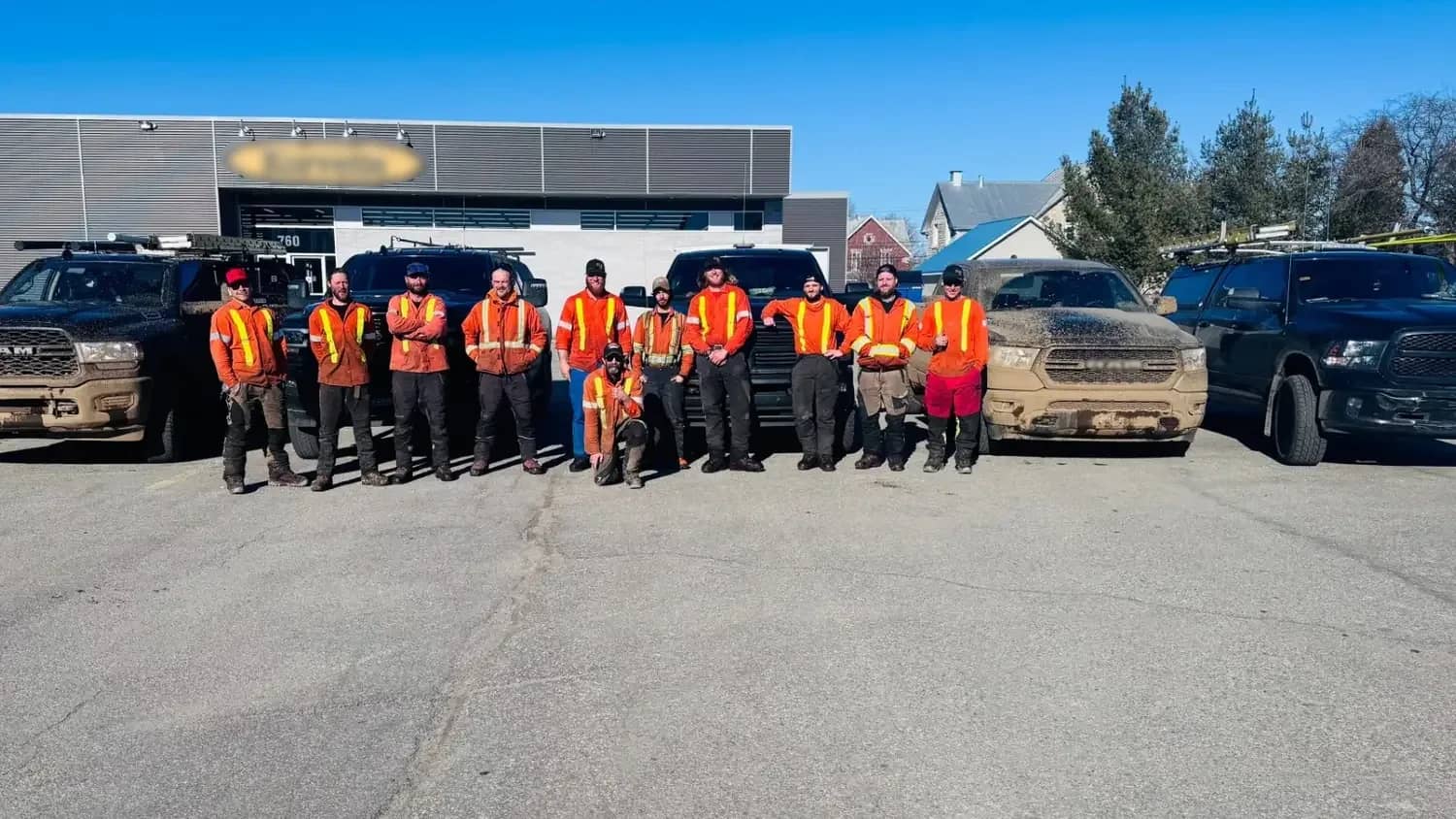 L’équipe Pirax en vestes haute visibilité devant ses camionnettes